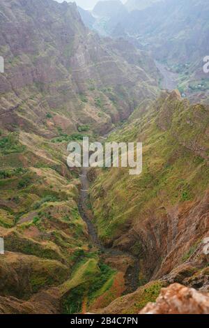 Vista mozzafiato del canyon con scoscesa scogliera e tortuoso letto del fiume con vegetazione lussureggiante sulla cresta di Delgadinho. Santo Antao, Capo Verde. Foto Stock