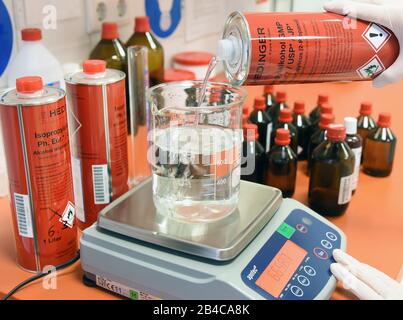 Lipsia, Germania. 06th Mar, 2020. In un laboratorio del Rosenapotheke am Auwald di Lipsia, un farmacista riempie un bicchiere di alcol isopropilico per una soluzione igienica per la disinfezione delle mani secondo le raccomandazioni DELL'OMS. A causa della grande richiesta di questi disinfettanti, i dipendenti stanno producendo questa soluzione di disinfezione per le mani dal 2-propanolo (alcol), perossido di idrogeno, glicerolo e acqua purificata fornita dal grossista da giovedì, 05.03.2020. Credit: Waltraud Grubitzsch/Zb-Zentralbild/Dpa/Alamy Live News Foto Stock