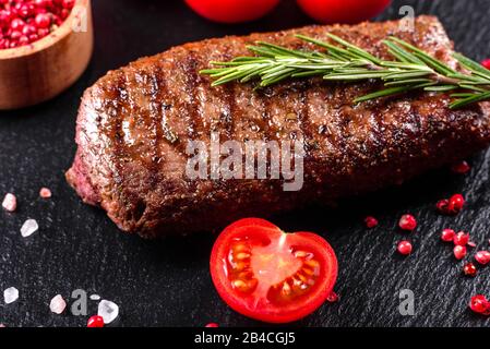 Bistecca Ribeye con patate, cipolle e pomodori ciliegini. Bistecca succosa con burro aromatizzato Foto Stock