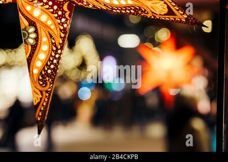 Primo piano di stelle colorate illuminate sull'albero di Natale al mercatino di Natale di Amburgo, Germania. Foto Stock