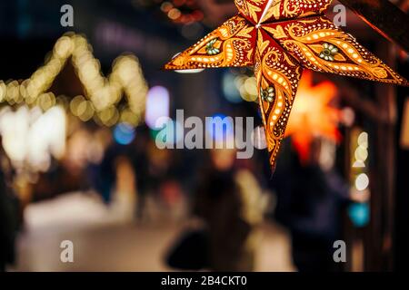 Stelle coloree illuminate sull'albero di Natale al mercato di Natale ad Amburgo, Germania. Foto Stock