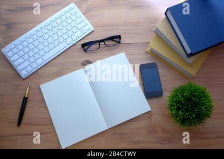 vista dall'alto di tastiera, tastiera, smartphone e libri sul tavolo Foto Stock