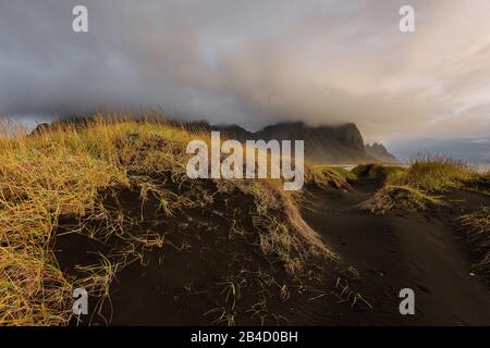 Il paesaggio è magico e delle montagne Vestrahorn nero e le dune di sabbia in Islanda a sunrise. Vista panoramica del promontorio Stokksnes in un Colorfulseascape. Foto Stock