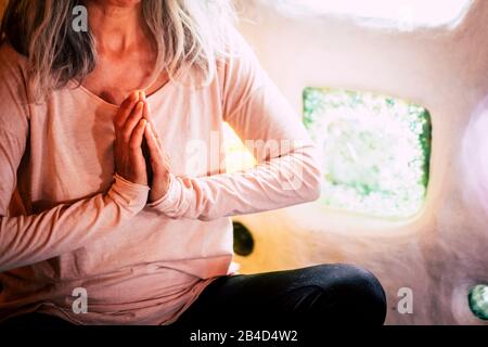 Alternativa irriconoscibile donna caucasica rilassata meditando e rilassarsi a casa in posizione di equilibrio yoga - parete artistica con vetro colorato sullo sfondo Foto Stock