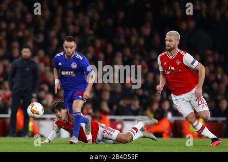 CAFU of Olympiacos combatte con Hector Bellerin (L) e Shkodran Mustafi (R) dell'Arsenal - Arsenal / Olympiacos, UEFA Europa League - Round of 32 Second Leg, Emirates Stadium, London, UK - 27th Febbraio 2020 Foto Stock