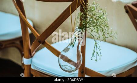 Nozze originali decorazioni floreali in forma di mini-vasi e i mazzi di fiori appesi dalla sedia Foto Stock