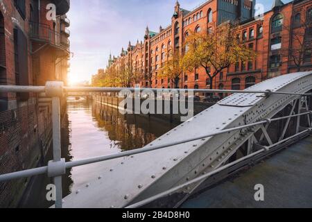 Arco ponte sui canali nel quartiere storico magazzino di Amburgo, nella calda luce del tramonto, Germania, Europa Foto Stock