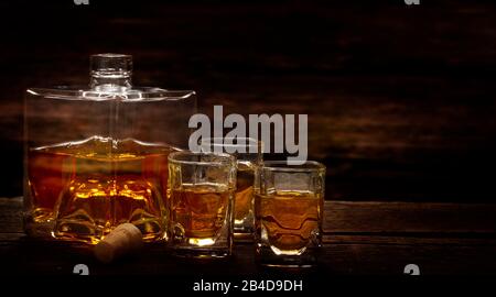 Versare il whisky dalla bottiglia in bicchieri da whisky in un bar Foto Stock