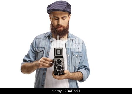 Ragazzo hipster barbuto con una fotocamera vecchio stile isolato su sfondo bianco Foto Stock