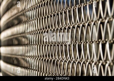 Una vista ravvicinata di una fence di collegamento a catena crea una ripetizione astratta. Foto Stock