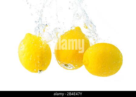 I limoni si tuffano in acqua e affondano su sfondo bianco. Foto Stock