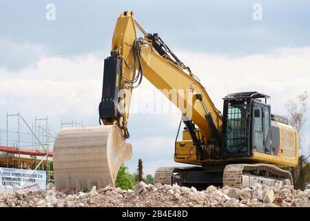 Un non-escavatore lavoro sorge su un cumulo di macerie di un sito in costruzione. Foto Stock