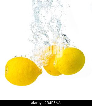 I limoni si tuffano in acqua e affondano su sfondo bianco. Foto Stock