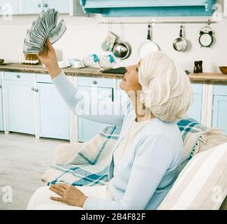 Donna Anziana Gioisce Tenendo Fan Of Money In Mano Foto Stock