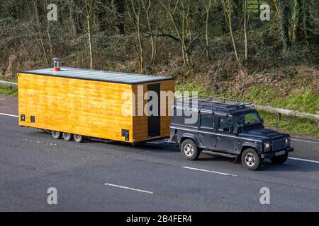 Land Rover Defender traino casa fatto caravan camper in legno. Un rimorchio con stufa a tubo a Manchester, Regno Unito Foto Stock