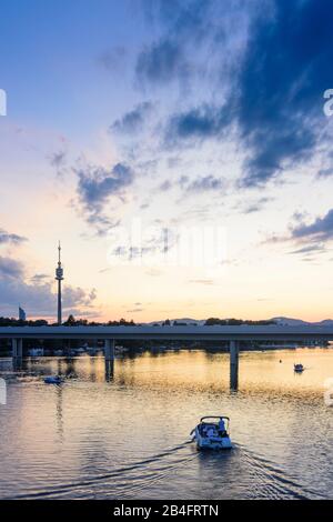 Vienna / Vienna, lago d'OXBow Alte Donau (Vecchio Danubio), tramonto, torre Donauturm, ponte metropolitana linea 1, barca in 22. Donaustadt, Wien, Austria Foto Stock