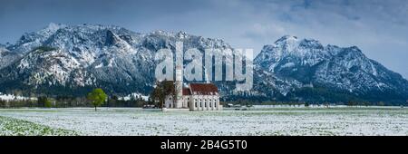 Chiesa barocca di San Colombano, dietro di essa il massiccio montuoso Tegelberg, 1881m, e la Säuling, 2047m, Schwangau, Ostallgäu, Allgäu, Swabia, Baviera, Germania, Europa Foto Stock