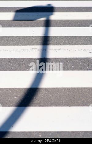 Un impressionante e lanterna ombra sul crosswalk di un attraversamento pedonale. Foto Stock