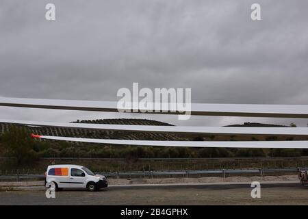Pale del rotore del mulino ad aria trasportate da rimorchi con vetture di avvertimento dietro di loro Foto Stock