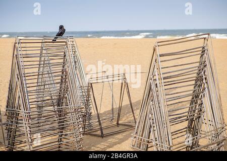 Scaffalature in metallo su uno stand con mare su cui si trova un corvo Foto Stock