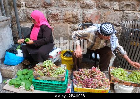 Coppia musulmana, vestita con abiti tradizionali musulmani, cernita attraverso le verdure. Città Vecchia - Gerusalemme. Israele Foto Stock