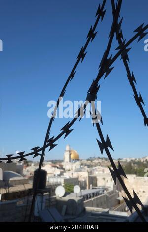 Israele - Gerusalemme. Cupola della roccia e del Muro Occidentale vista attraverso una recinzione di filo di rasoio Foto Stock