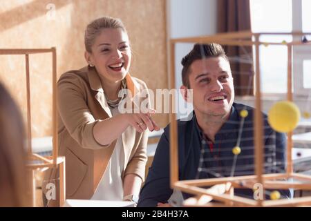 Insegnante di architettura femminile al lavoro. La professoressa spiega i progetti architettonici agli studenti. Bella donna professore di architettura universitaria Foto Stock