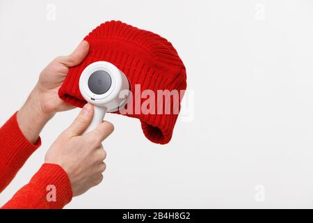 da acrilico o lana su un berretto. Dispositivo elettrico dopo la pulizia e raccolta lanugine/lanugine, isolato su sfondo bianco con spazio di copia. Foto Stock