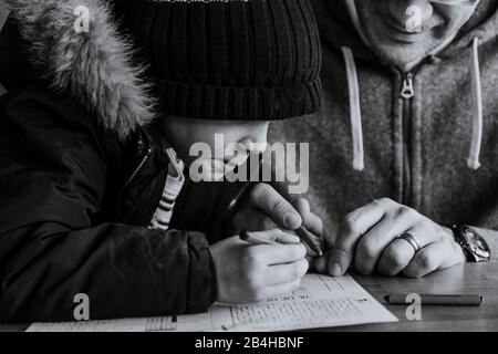 Primo piano in bianco e nero di padre e figlio che colorano a tavola Foto Stock