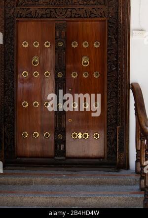 Destinazione Tanzania, Isola di Zanzibar: Impressioni da Stone Town, il più antico distretto di Zanzibar, la capitale dello stato tanzaniano di Zanzibar. Porta in legno nobile Foto Stock