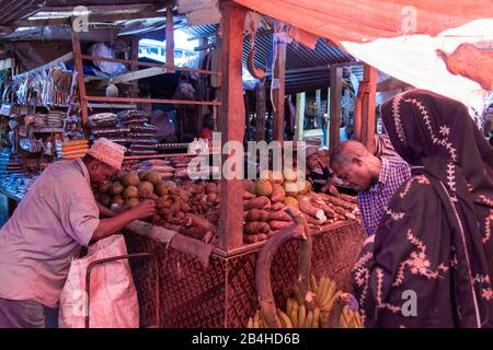 Destinazione Tanzania, Isola Zanzibar: Impressioni da Stone Town, il più antico quartiere di Zanzibar, la capitale dello stato tanzaniano Zanzibar alla fine del Ramadan. Commerciante di verdure con i clienti. Foto Stock