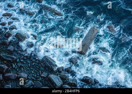 Scena di spiaggia rocciosa costale ripresa dall'alto in Scozia con onde Foto Stock