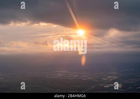 Vista dalla finestra di un aeroplano al tramonto con un'impressionante luce che gioca sul paesaggio tedesco meridionale Foto Stock