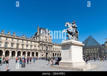 Turisti di fronte al Musee du Louvre, la piramide di vetro e la statua equestre di Re Luigi XIV, Parigi, Francia, Europa Foto Stock