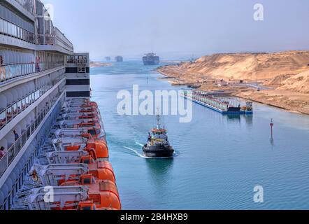 Vista laterale con ponte barca e balconi del transatlantico Liner Queen Mary 2 con convoglio nave nel canale di Suez (canale di Suez), Egitto Foto Stock