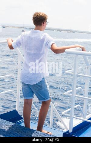 Ragazzo, stand, barca, da dietro Foto Stock