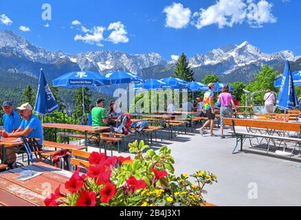 Terrazza solarium dalla montagna inn Eckbauer 1237m contro Dreitorspitze 2633m e Alpspitze 2628m nelle montagne Wetterstein, Garmisch-Partenkirchen, Loisachtal, Werdenfelser Land, Zugspitzland, alta Baviera, Baviera, Germania Foto Stock