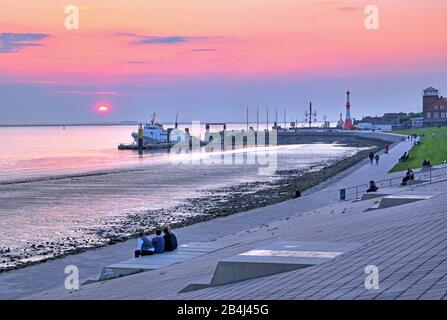 Passeggiata sulla diga Weser con il molo e il faro Minaret al tramonto, Bremerhaven, Weser, estuario Weser, Land Bremen, Germania Foto Stock