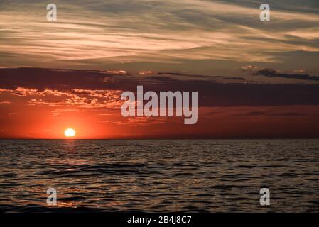 Vista sul Mar Baltico sulla penisola Fischland Darß con poco prima nel mare tramonto del sole con cielo drammatico in estate Foto Stock