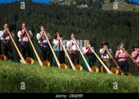 Austria, Vorarlberg, piccolo Walsertal, Baad, Alphorn Festival, ventilatore Alphorn, prato. Foto Stock