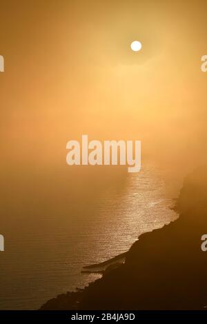 Cielo nuvoloso nella nebbia al tramonto, scogliera ad Arco da Calheta, Isola di Madeira, Portogallo Foto Stock