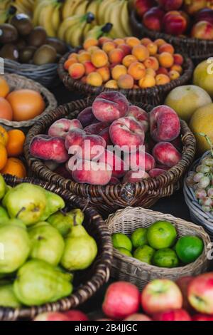 Vari tipi di frutta in cesti per la vendita, primo piano Foto Stock