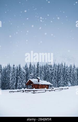 Paesaggio invernale con casa in legno sulle montagne innevate, Valle Ansiei, Auronzo di Cadore, Belluno, Veneto, Italia Foto Stock