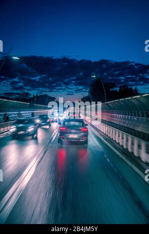 traffico serale di auto in città, ponte alpini, belluno, veneto, italia Foto Stock