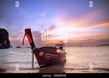 Barca a coda lunga al tramonto a Railay Beach, Krabi Thailandia Foto Stock