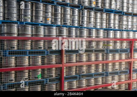 Brisbane, Australia - 8 Dicembre 2009: Fabbrica Di Birra Castlemaine Perkins. Parete di pile di fusti di metallo su pallet blu. Recinzione rossa di fronte. Foto Stock