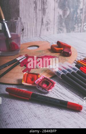 Disposizione di varie penne e utensili da pittura nel colore rosso Foto Stock