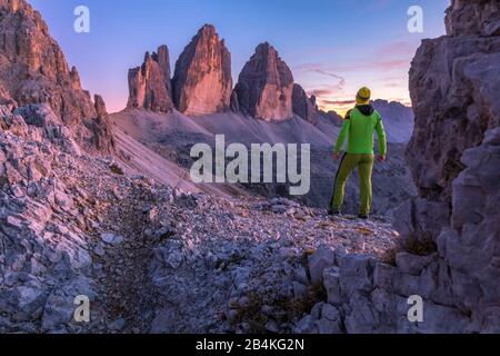 L'uomo in piedi ammira le tre cime di lavaredo al tramonto, Bolzano, Alto Adige, Italia, Europa Foto Stock