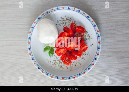 Cibo italiano, caprese, mozzarella e pomodori e origano Foto Stock