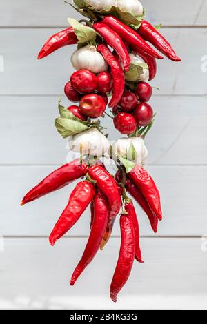 Trecce di peperoni caldi e aglio appesi in un mercato di prodotti locali a Baska, isola di Krk, Kvarner Bay, Primorje-Gorski Kotar County, Croazia Foto Stock